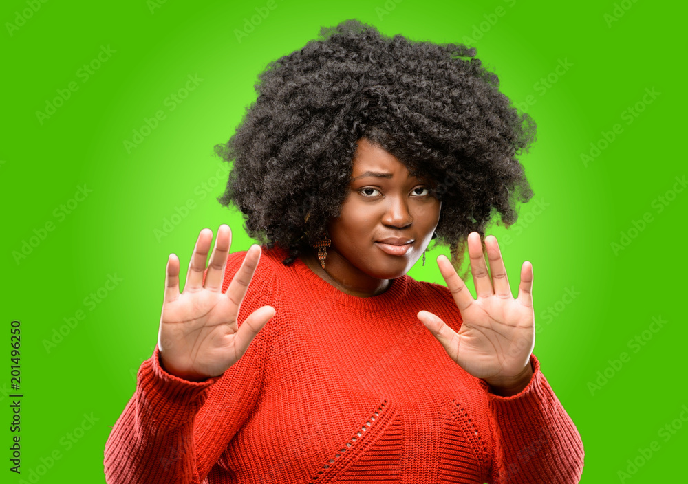 Beautiful african woman disgusted and angry, keeping hands in stop gesture, as a defense, shouting Beautiful african woman disgusted and angry, keeping hands in stop gesture, as a defense, shouting