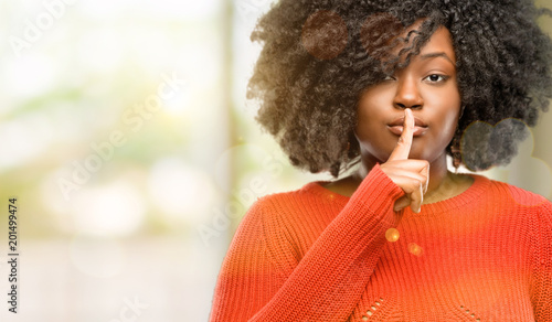 Принти на полотні Beautiful african woman with index finger on lips, ask to be quiet