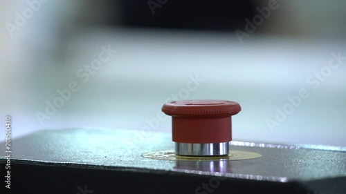 The worker presses the button of the emergency stop