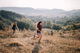 Beautiful young girls walk on autumn mountain slopes, fun, jump. female friendship