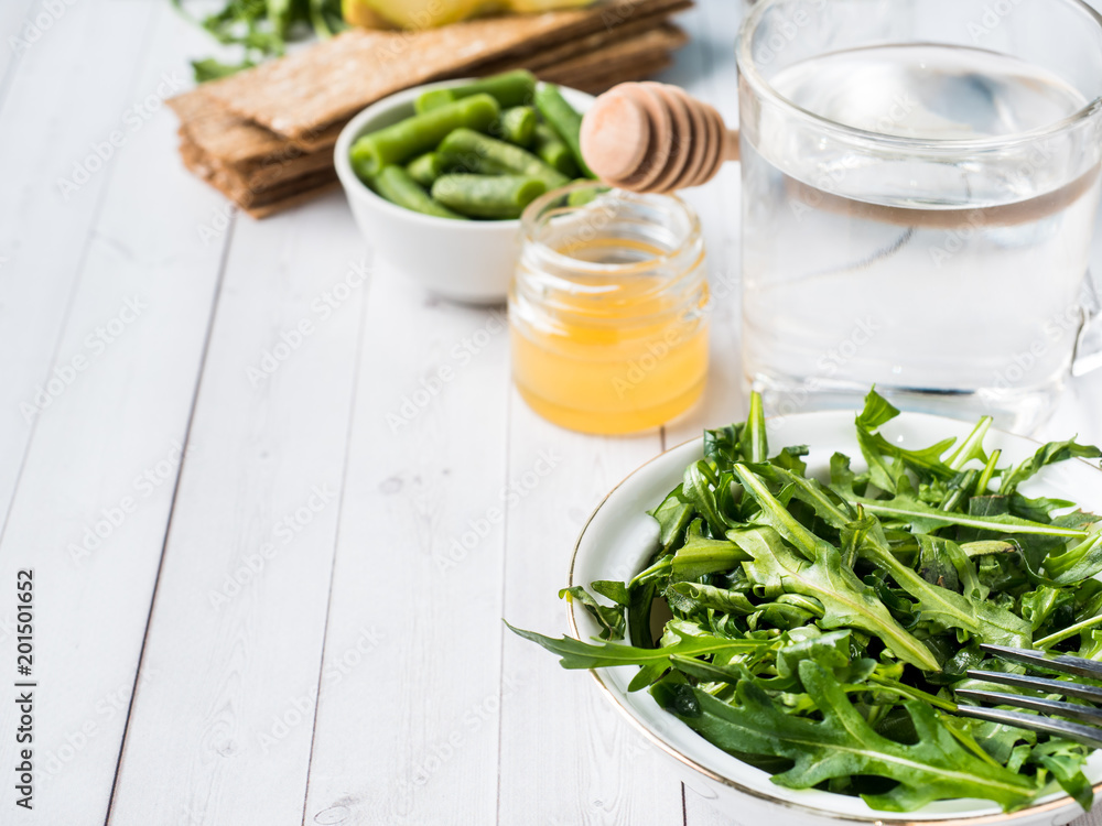 Healthy diet food on the table Arugula Green Beans Apple Water Honey Cracker Healthy diet food on the table Arugula Green Beans Apple Water Honey Cracker