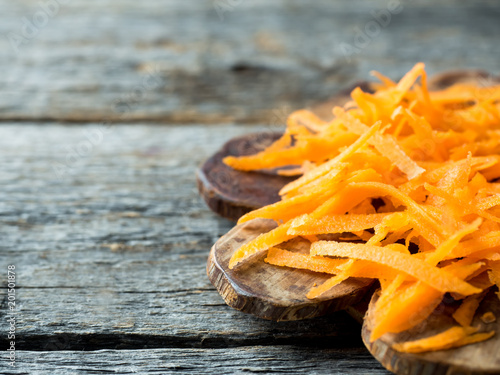 Grated carrots on a wooden rustic background Copy space photo