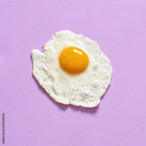Fried egg on a lavender background. Flat lay, copy space