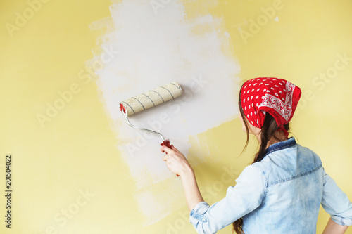 Photography Beautiful girl in red Headband painting the wall with paint roller