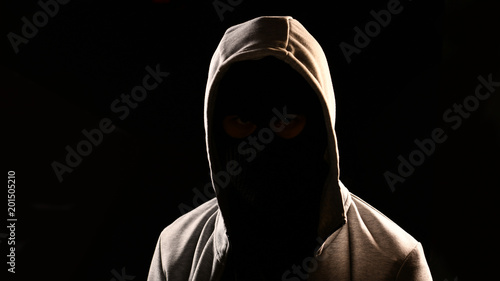 Mysterious man with hoodie on the black background photo