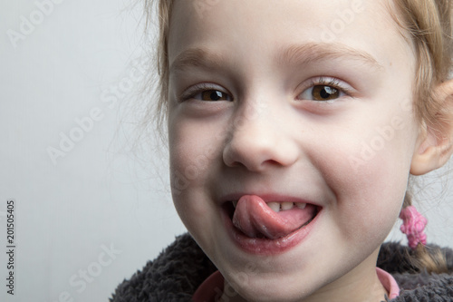 Photography Happy little girl showing her tongue.