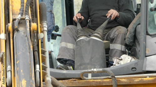 The bucket of the excavator digs the ground
