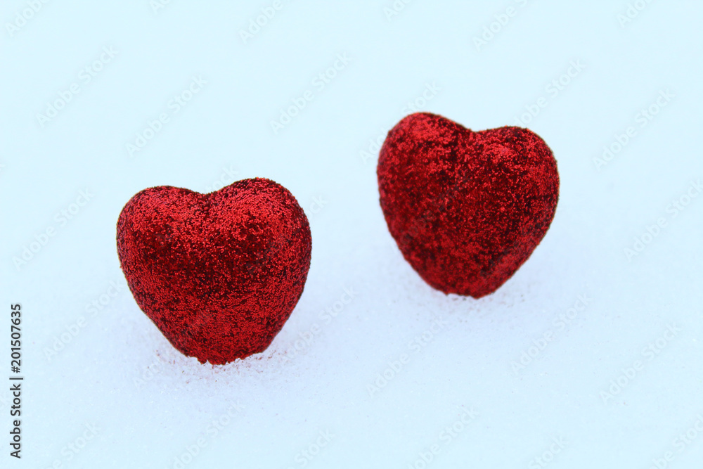 Fototapeta premium Beautiful red volumetric hearts on white snow. Close-up. Background.