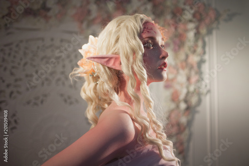 Attractive elf portrait on light background. Fantasy and fairy tale, computer games. photo