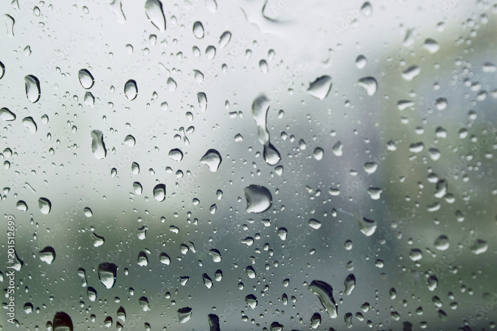 Raindrops on glass surface in rainy day,Water droplets attached on the glass, lonely color tone Raindrops on glass surface in rainy day,Water droplets attached on the glass, lonely color tone