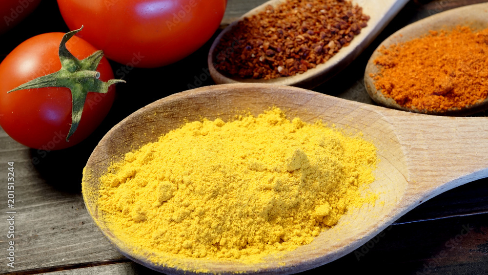 Close up turmeric with paprika, pepper flakes and red cherry tomatoes. Close up turmeric with paprika, pepper flakes and red cherry tomatoes.