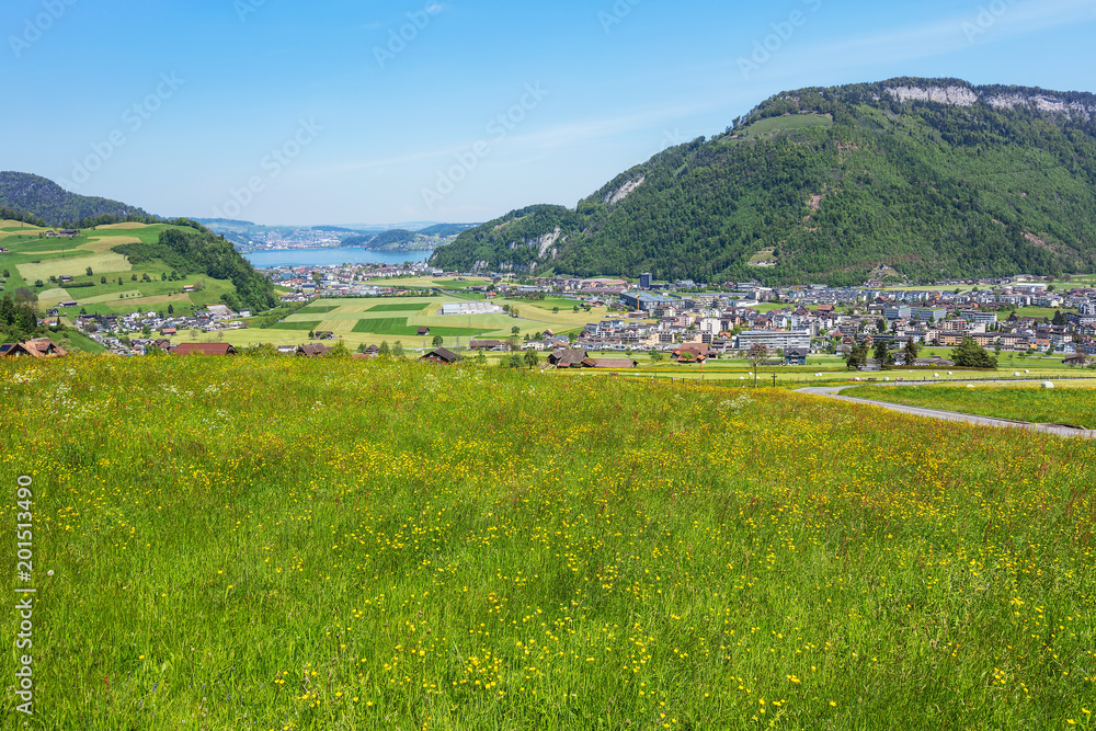 Springtime view from the foot of Mt. Stanserhorn in the Swiss canton of Nidwalden, buildings of the town of Stans and Lake Lucerne in the background