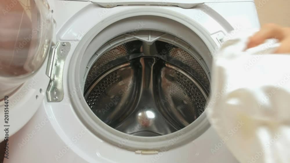 Laundry. Man puts white linen in the washing machine. Closeup hand. Laundry. Man puts white linen in the washing machine. Closeup hand.