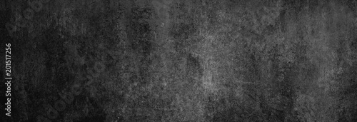 Beton-Textur in fast schwarz in XXL-Größe als Hintergrund, auf die Betonwand fällt leichtes Licht photo