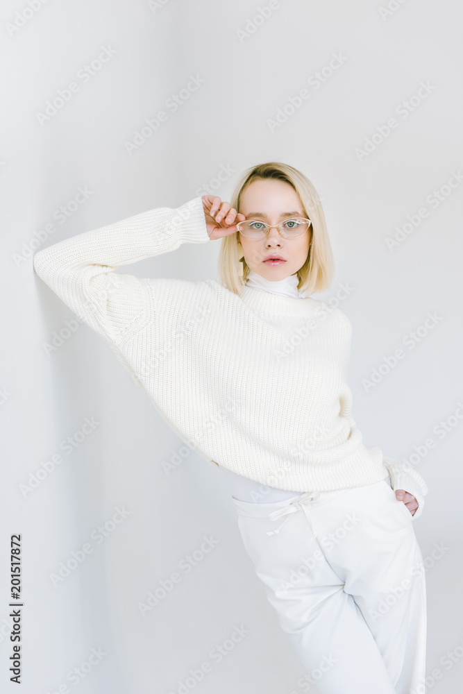 beautiful stylish blonde woman in white clothes leaning on white wall beautiful stylish blonde woman in white clothes leaning on white wall