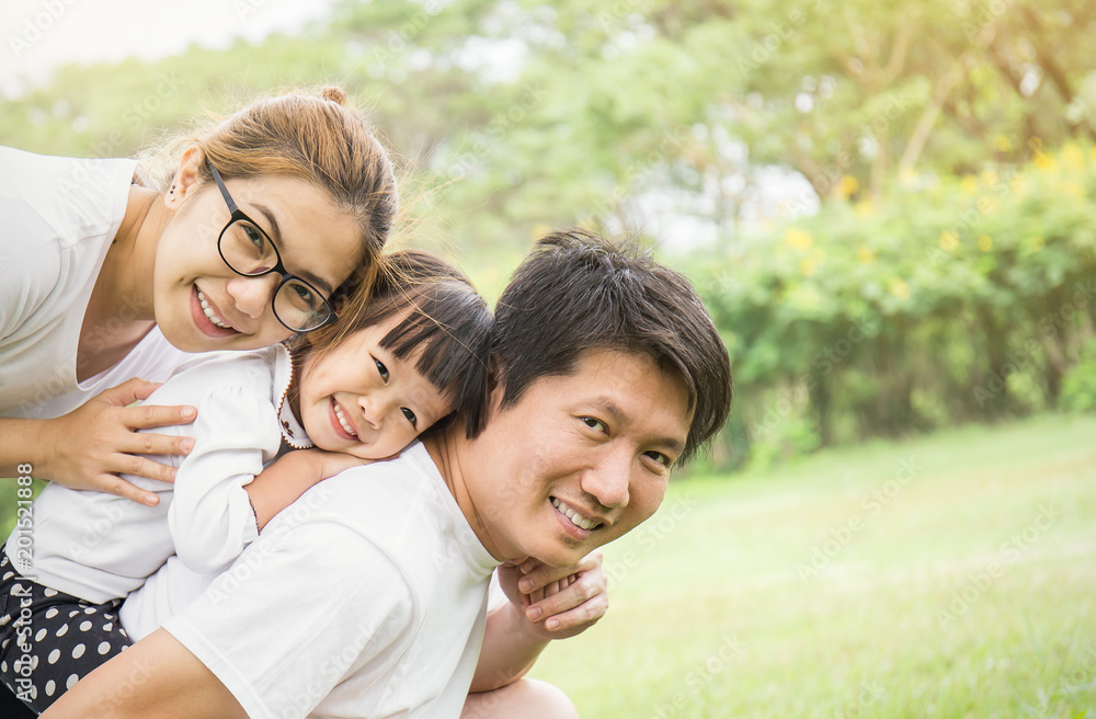 Portrait of happy family man woman and little girl playing outside ...