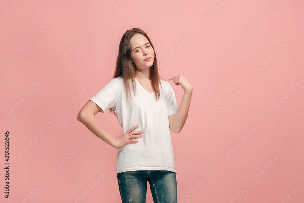 The happy teen girl standing and smiling against pink background. The happy teen girl standing and smiling against pink background.