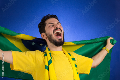 Supporter of National Team of football is holding the Brazil flag. photo