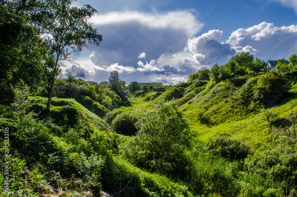The ravine in the spring outside the city. Rain clouds shine through The ravine in the spring outside the city. Rain clouds shine through