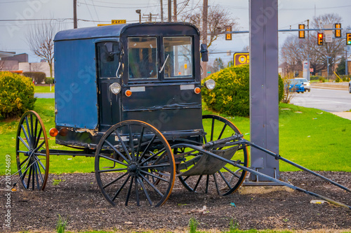 Outdoor view of old Amish carriage parked at one side of the rural road in Lancaster County