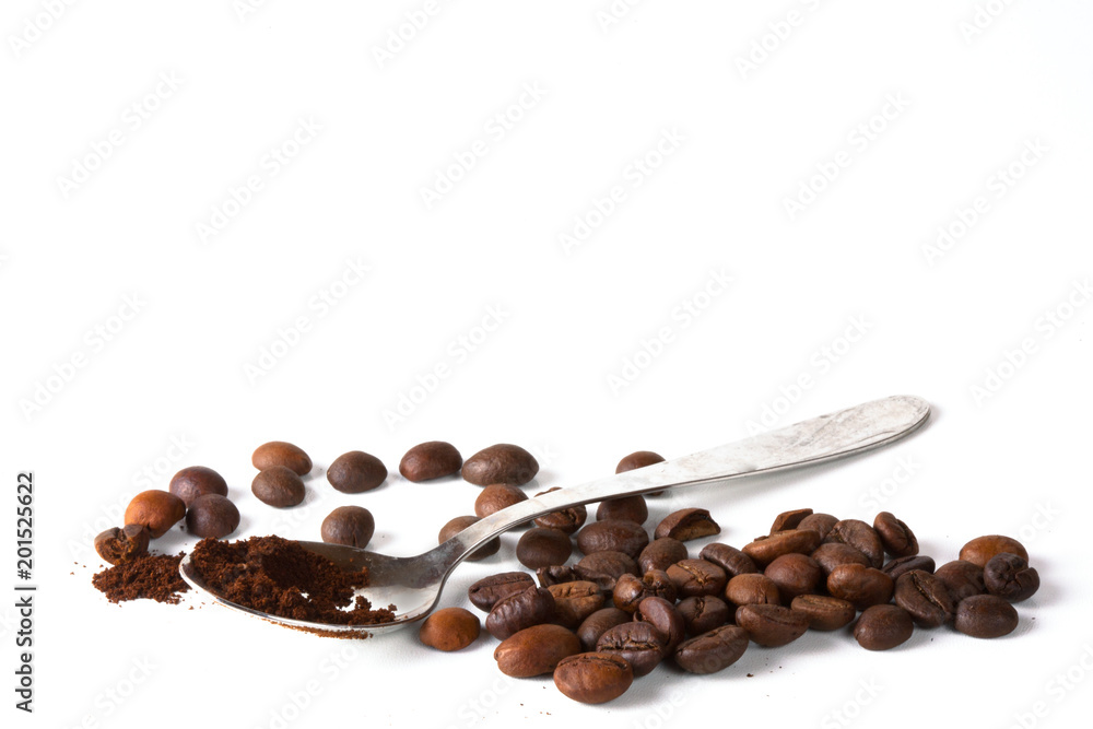 Naklejka premium Grain of coffee, beans and a coffee spoon on a white background. Close-up