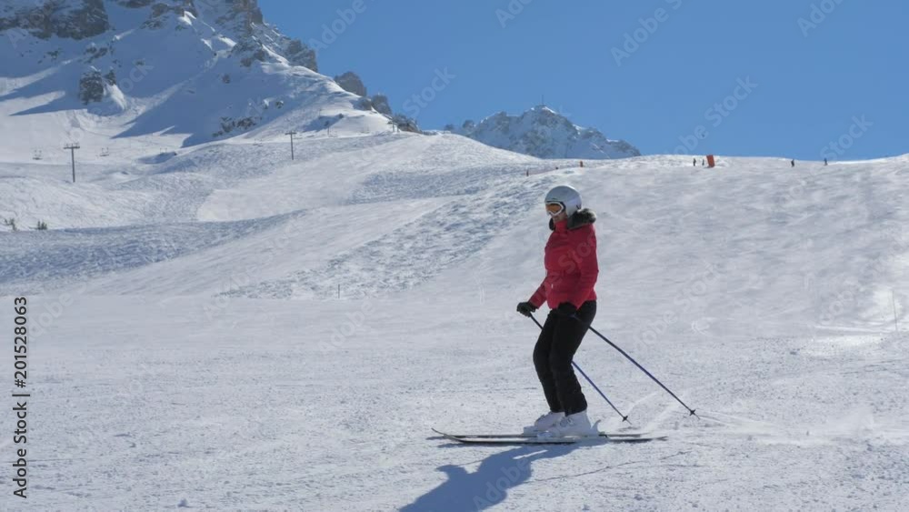 Woman Skier Skiing Along The Slope In The Mountains In Winter Woman Skier Skiing Along The Slope In The Mountains In Winter