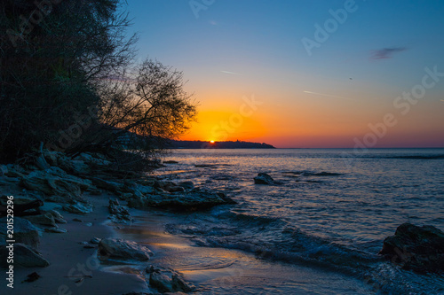 Sunrise on the beach with rocks and trees