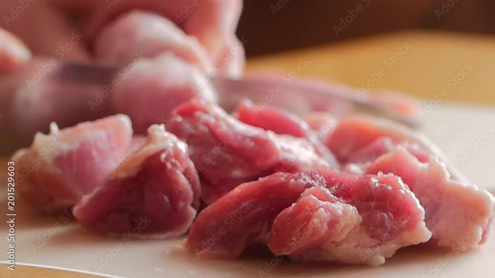 The chef cuts raw meat with the knife The chef cuts raw meat with the knife