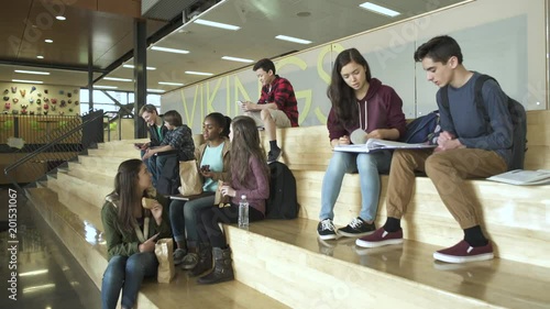 Wide shot of students sitting and learning on the stairs