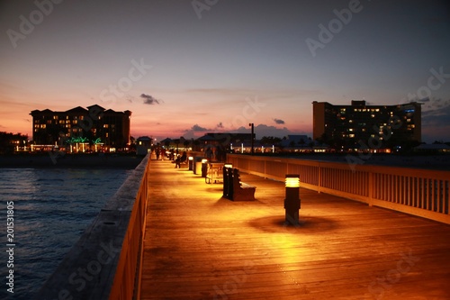 Deerfield Beach, Florida Pier Boardwalk After Dusk with Lights Illuminated, Park Sitting Benches, Atlantic Ocean on Either Side and Wyndham Hotel in the Distance
