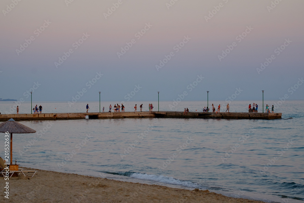 People on a pier in soft dawn light