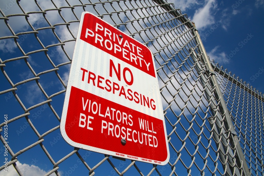 Private Property No Trespassing Violators Will Be Prosecuted Sign on Chain Link Fence Overlooking Grassy Field, Bright Sunny Day with Scattered Clouds in February Private Property No Trespassing Violators Will Be Prosecuted Sign on Chain Link Fence Overlooking Grassy Field, Bright Sunny Day with Scattered Clouds in February