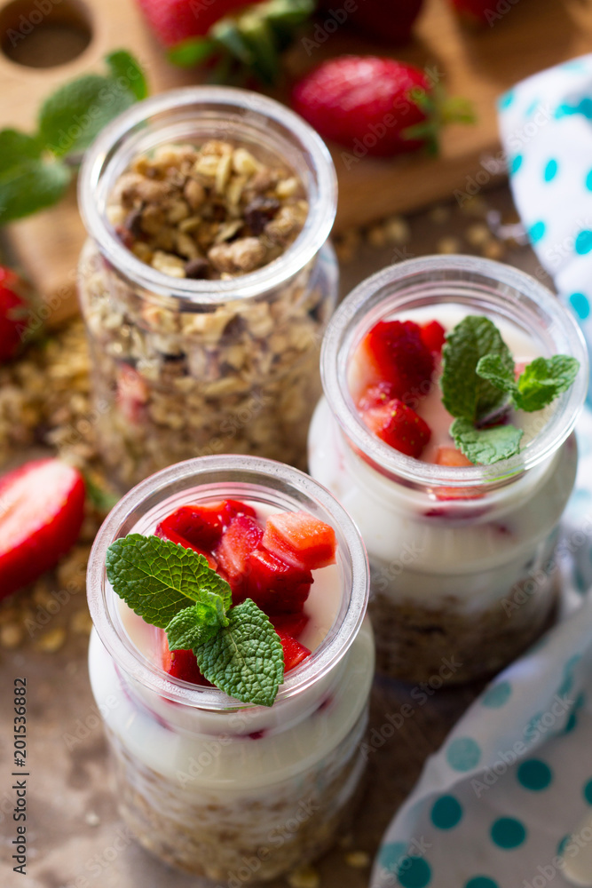 Homemade healthy breakfast with homemade baked granola, fresh strawberry and yogurt close-up on stone or concrete table. Homemade healthy breakfast with homemade baked granola, fresh strawberry and yogurt close-up on stone or concrete table.