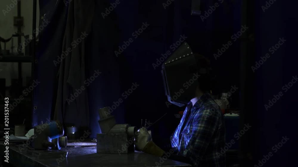 Young woman welding a pipe in a factory Young woman welding a pipe in a factory