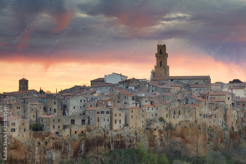 colored clouds above roofs of old city in Tuscany in Italy
