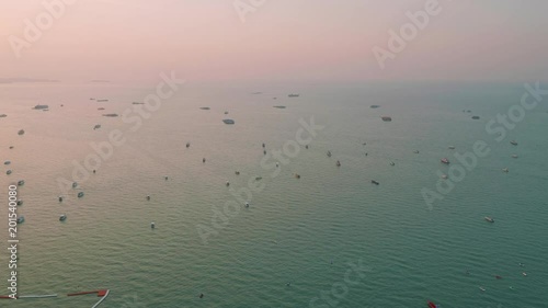 Up view of boats and ship in Pattaya bay in sunbeams during picturasque sunset photo