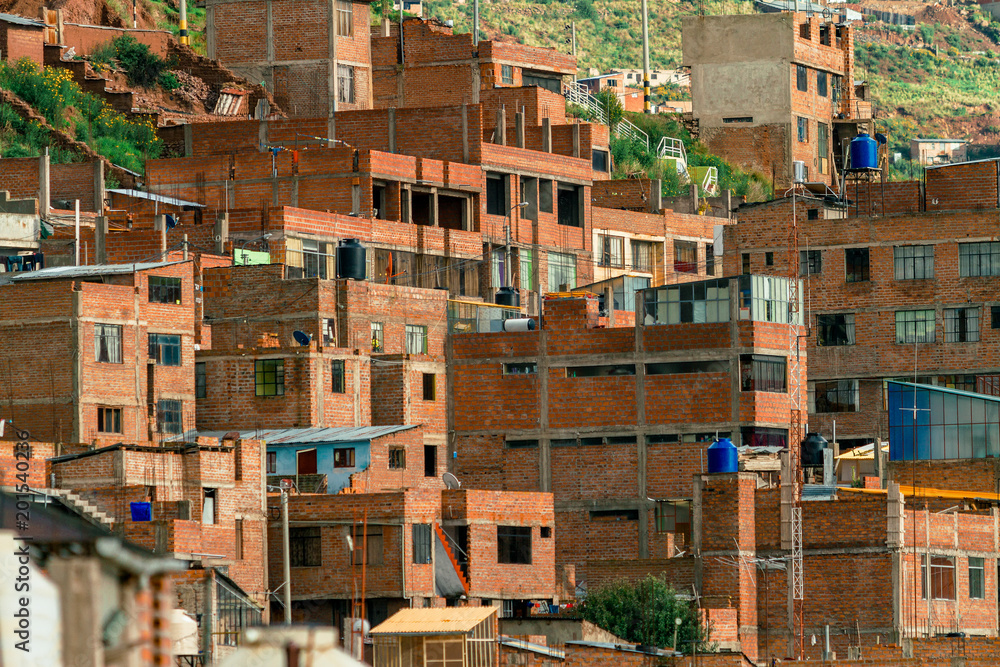 Dozens of rudimentary houses on the slope of a mountain in Puno, Peru