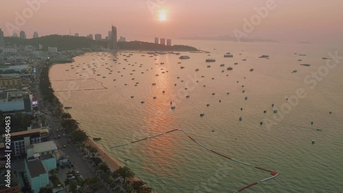 Up view of boats and ship in Pattaya bay in sunbeams during picturasque sunset photo