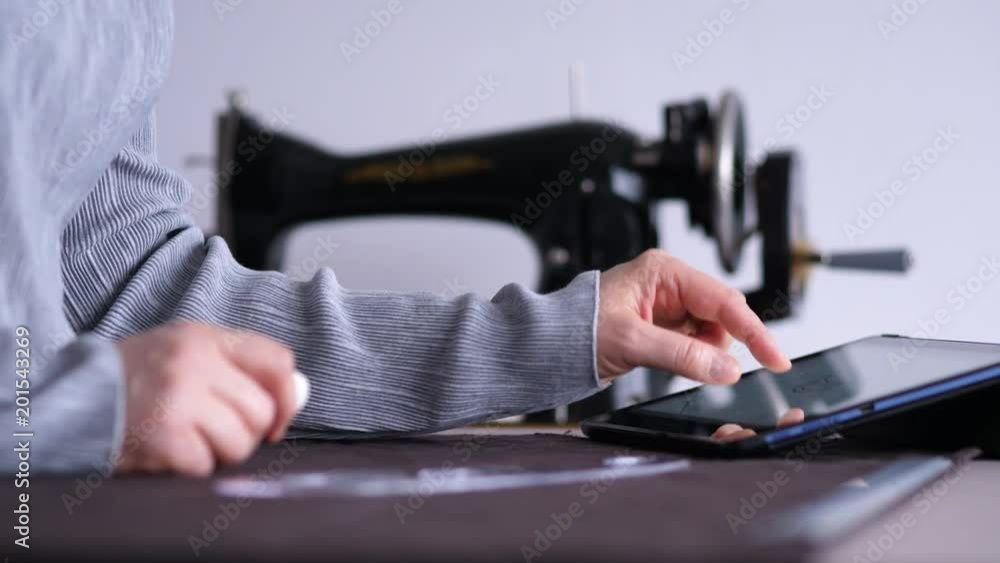 Fashion designer working on table. А female hand draws a pattern on the fabric. Fashion designer working on table. А female hand draws a pattern on the fabric.