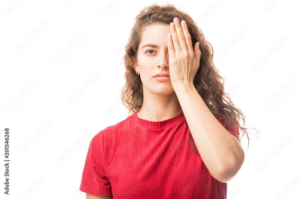 Young woman covering one eye Young woman covering one eye
