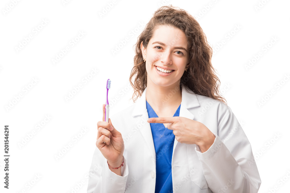 Smiling female doctor showing a tooth brush Smiling female doctor showing a tooth brush