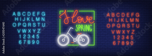 Neon alphabet and I Love Spring text with bicycle in frame over brick background. Spring sale, bicycle store, bicycle parking. Spring concept. For signboards, template design, banners