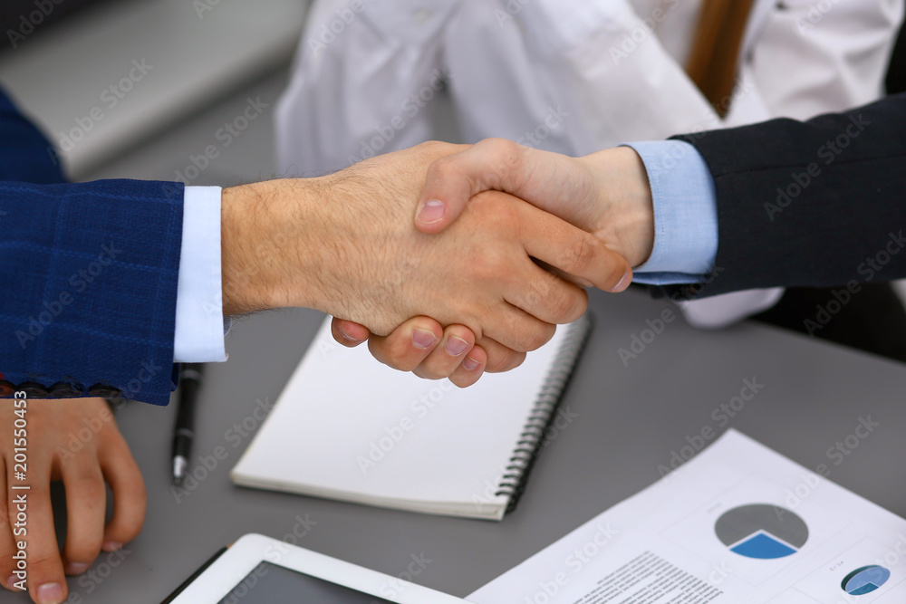 Business people shaking hands, finishing up a papers signing. Meeting, agreement and lawyer consulting concept Business people shaking hands, finishing up a papers signing. Meeting, agreement and lawyer consulting concept