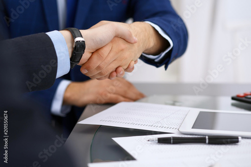 Business people shaking hands, finishing up a meeting. Audit, tax service or agreement concept