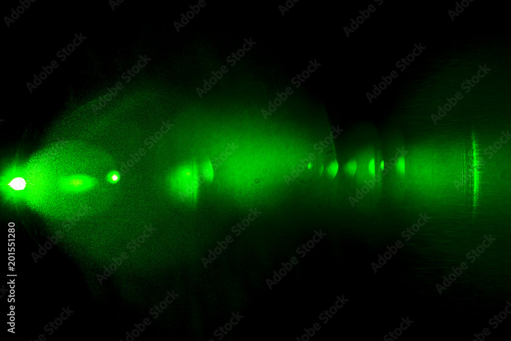 Camera lens flare by laser light create hexagons of objective iris shapes of number depending on number of lens surface and interferent effect and moire on digital sensor on dark black background Camera lens flare by laser light create hexagons of objective iris shapes of number depending on number of lens surface and interferent effect and moire on digital sensor on dark black background