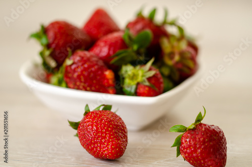 Fresh strawberries in a bowl on wooden table