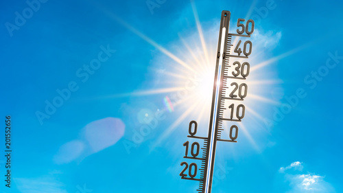 Foto Summer background, bright sun with thermometer