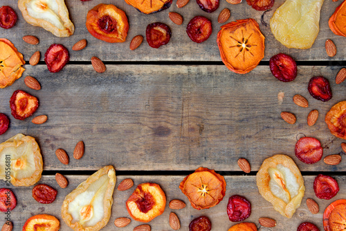 Dried Fruit and Nut Border Frame in Autumn Colors with Wood Background