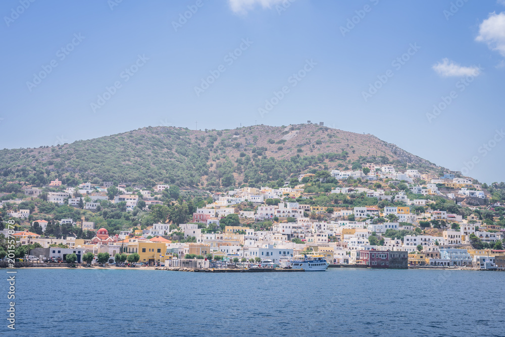 Beautiful sunny greek village town harbor view to the aegean blue sea with crystal clear water boats cruising surrounded by hills mountains windmills, Agia Marina, Leros, Dodecanese Islands, Greece