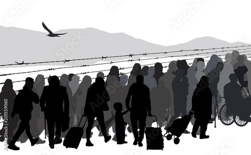 Silhouettes of refugees people behind barbed wire
